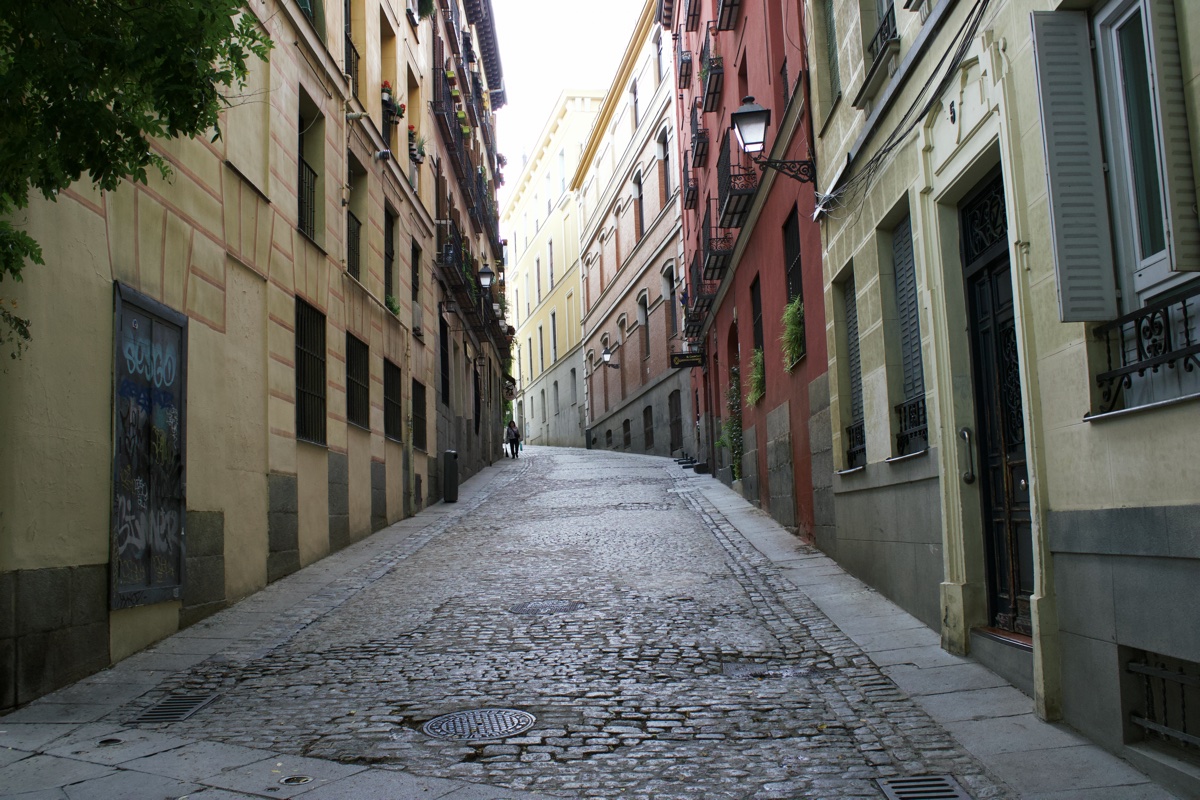Cobblestone street between pastel façades on Calle de Afonso VI, Madrid